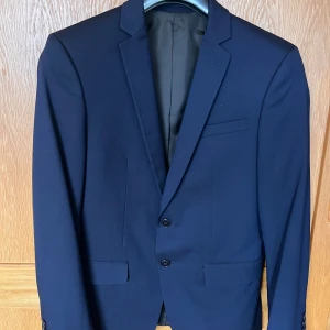 Mörkblå Kavaj från Zara - Mörkblå kavaj från Zara. Skick 9/10, använd fåtal gånger. Strl 44, motsvarar small. 