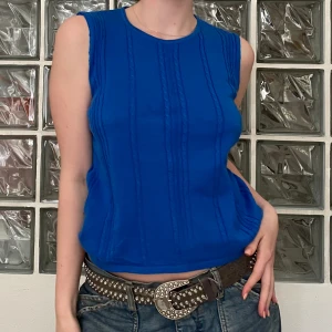 Blå stickad topp -  Blå stickad topp med avklippta ärmar som jag sytt och fixat till själv 😊 Otrolig färg!!!💙säljer billigt! Strl M men passar S :)