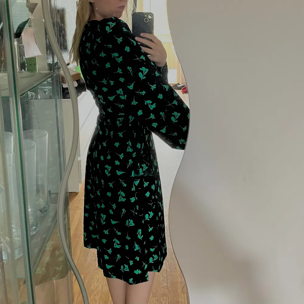 Fin oanvänd långärmad klänning med gröna mönster/detaljer. Aldrig använt . Klänningar.