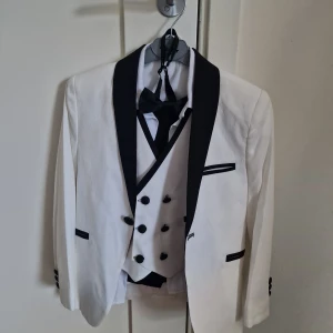 Vit Kostymset för Barn - Rensar familjens garderober så säljer min lillebrors kostymset. Settet består av svarta kostymbyxor, en vit skjorta, vit väst och en vit kavaj. Den har anvämds bara 1-2 gånger. De passar Pojkar som är runt 5-6 år. Släpper den för 499:-