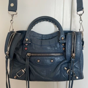 Balenciaga city bag blå  - Superfin liten balenciaga city bag i en blå färg. Väskan har lätt slitage på kanterna som inte är anmärkningsvärt vid användning. Köpt på Harrods i London med medföljande dustbag och liten spegel 😇🌸