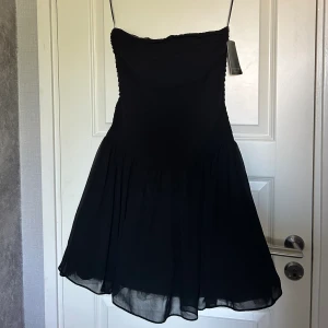 strapless svart ZARA klänning - Helt ny, med prislapp.  Strapplessmodell med puffig ”kjol”. Passar till många olika tillfällen & ser väldigt dyr & lyxig ut.  Nypris: 559kr  Vid frågor/funderingar/fler bilder kontakta mig!🖤