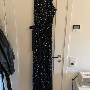 Balklänning  - Otroligt vacker klänning i marinblå glitter den har siden band runt midjan och en slits som går en liten bit upp vid benet!  använd 1 gång och är i nyskick. 