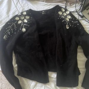 Stickad kofta kort - Kort stickad kofta med palleter från hm jätte söt den är i storlek M men passar mig som har S eller xs