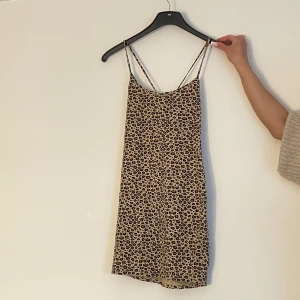 Leopard klänning  - En kort leopard klänning, med x på ryggen. Klänningen går och klä upp med fina smycken och klackar. 