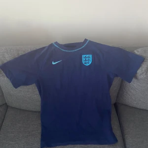 England tröja - Jag säljer en riktigt snygg England T-shirt. Den är typ helt ny använd bara nån gång. Tagg finns kvar men inte på. Den är från unisportstore. Perfekt inför EM.