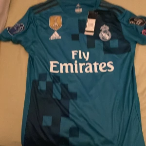 Real Madrid tröja Ronaldo  - Den ör stor i storleken passar M!!  Aldrig använd taggar finns kvar. Pris kan diskuteras 