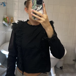 Blus - Jättefin blus med volanger på axlar och mage, även knappar längs med  hela ryggen.