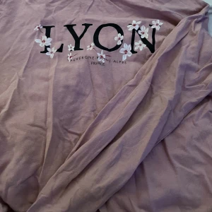 Tunn rosa tjocktröja ( långärmad)  - En rosa tunn långärmad/tjocktöja med blommor och text ( Lyon auvergne-Rhône- alpes france)  ( köparen står för frakt)