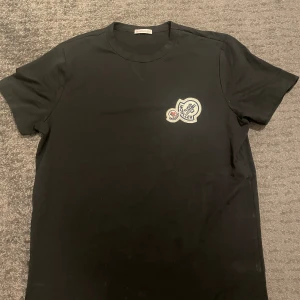 Moncler Double Logo Patch T-shirt - Moncler t-shirt i storlek S säljes då den inte är min smak längre. Helt ny och endast testad. I färgen svart. Rök- och djurfri miljö!