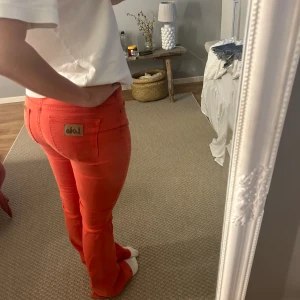 Orangea lois jeans  - Orangea/korall färgade jeans från lois. Toppskick. De är även stretchiga i materialet. Älskar de men de är tyvärr för tajta över lår och höfter på mig. Midjemått:33cm rakt över. Innerbenslängd: 79cm 