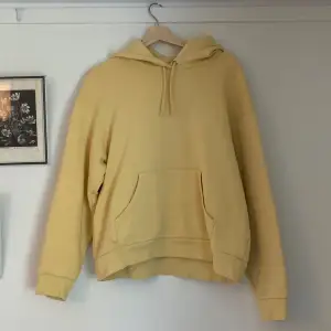 En gul hoodie med magficka och i oversize-modell. Är därav mer som storlek M.  Knappt använd och i bra skick!