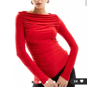 Röd assymetrisk topp  - ASOS DESIGN – Röd, långärmad topp i mesh med djup bardotringning. Kostar 289 på hemsidan, jag säljer för 200, pris kan absolut diskuteras. Mycket stretch. Helt oanvänd med prislapp kvar.