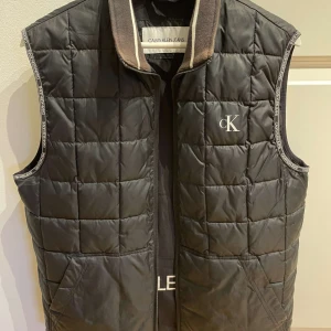 Calvin Klein väst. Storlek M, bra skick - En svart Calvin Klein väst perfekt för våren. Storlek M.  I bilderna testas västen på en man 186cm lång.
