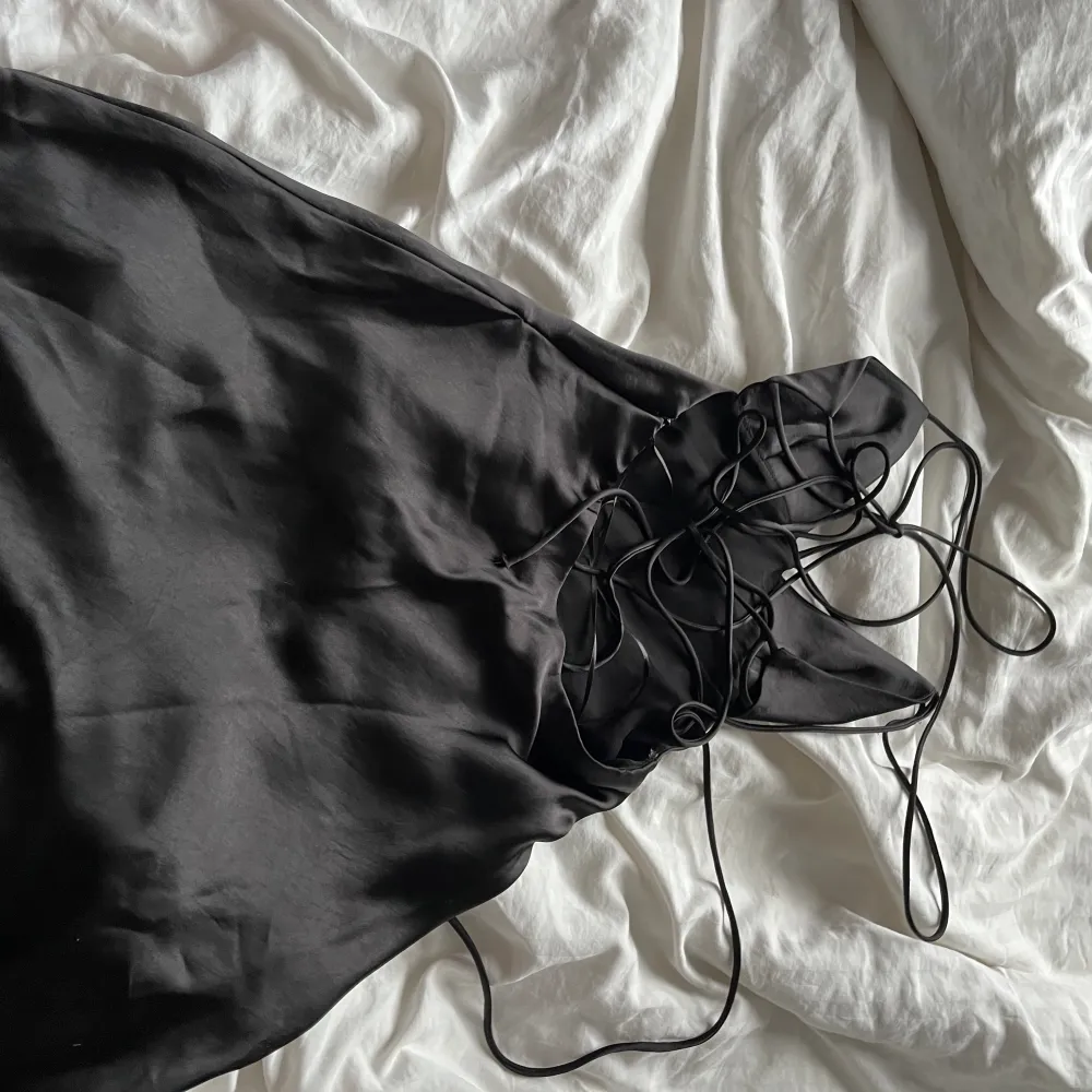 En jättefin svart klänning ifrån zara med knyte i ryggen som inte kommer till användning . Klänningar.