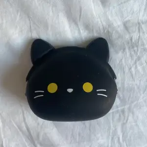 En väldigt gullig plånbok i form av en svart katt! Inte jätte stor och enkel att ta med sig ut. Den är gjord av gummi och skyddar därför mot alla väder! 