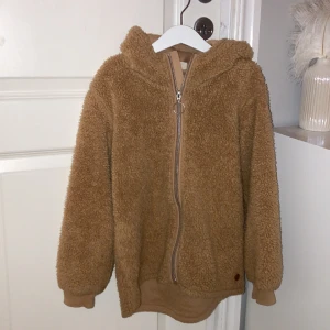 En  fin ljus brun fluffig höst jacka helt fläckfri går och använda till mycket ❤️ - Storlek 134/140 . Köpt: Kappahl. 