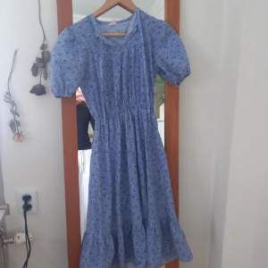 En blå mönstrad klänning. Den är i gått skick och har nästan aldrig använts. Storleken kan variera eftersom att den är stretching men skulle tippa på xs eller small.