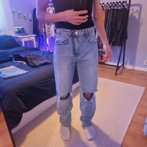 Jeans - High waist denim jeans i storlek 38 från ginatricot med två öppna hål vid knän på framsidan 