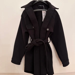 Jacka / kappa - Säljer oanvänd jacka, köpte förra året, inte kommit till användning. Den har både knappar och bälte🥰🖤