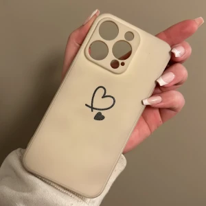 Beiget mobilskal med svarta hjärtan - iPhone 14 pro - Oanvänt skal till iPhone 14 PRO, beige med två svarta hjärtan🤗
