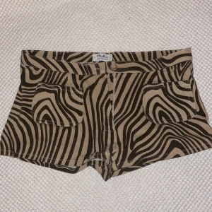 Lågmidjade shorts - Jag säljer dessa Lågmidjade jeanshorts, jag känner att de är lite för korta för mig men de är super snygga och coola. De har zebra mönster i beiget och svart. De har även två fickor längst fram. Köpta second han i Paris.