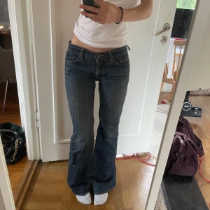 Lågmidjade bootcut jeans - Mörkblå lågmidjade bootcut vintage jeans med midjemått 37 och innerbenslängd 77. De har ett litet hål i innerlåret men inga andra defekter❣️