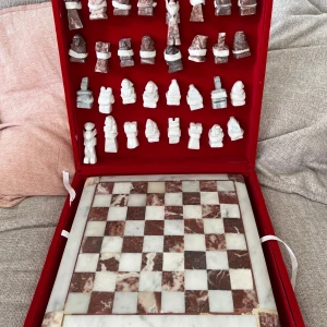 Schackbräde i marmor - Schackbräde i marmor (inklusive pjäser) med aztekiska motiv. Medföljande väska/etui. I mycket god skick med alla pjäser.  Kommer från ett djur- och rökfritt hem. Spelet har inga skador.