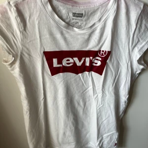 Levis t-shirt  - Levis-T-shirt. Den är absolut inte i dåligt skick men det märks att den är använd innan (mjukt material). ❤️Det ser ut som att den är lite rosa längst upp på tröjan men det är bara ”skuggan” av galgen.