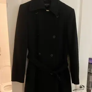 En lång svart kappa köpt på Inwear i storlek 38. Använd fåtal gånger och har märket prestige.