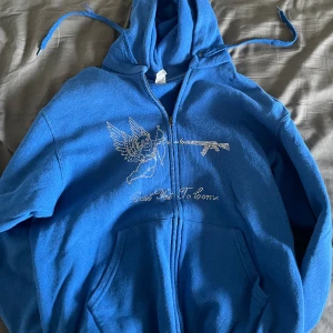Blå tröja med dragkedja  - Säljer min blåa super coola tröja med dragkedja med tryck! Köpte den av ett företag på instagram för kanske 2-3 år sedan, den är använd men tycker ändå att den är i bra skick! Matchar till allt och kan göra en hel outfit!! Nypris ungefär 450-500kr! 