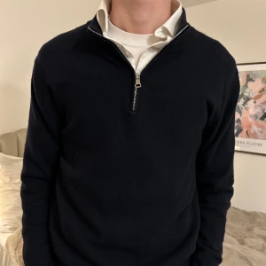 Halfzip tröja från Oscar Jacobsson  - Stilren Kashmir halfzip från Oscar Jacobsson. Tröjan är i grymt skick och är i mörkblå färg. Väldig snygg att kombinera med skjortor men även t-shirt!   Nypris för tröjan är 1600 kr!