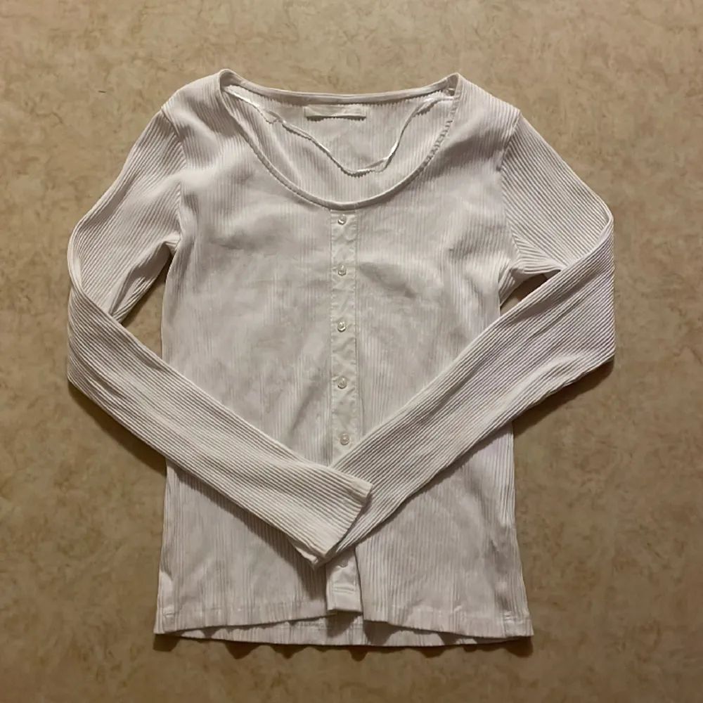 Säljer en vit tröja med knappar på. Den är ifrån ullared i storlek m. Har aldrig använts.. Tröjor & Koftor.