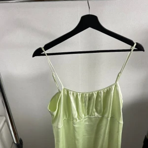 Grön långklänning  - En glansig grön klänning från Vero Moda. Aldrig använd bara provad. På mig som är 178 är den till anklarna. 