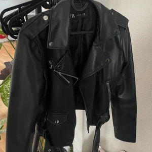 Skinnjacka Zara  - Den populära skinnjackan från Zara (inte äkta skinn). Använd fåtal gånger och i perfekt skick! Strl L men passar S-M också, croppad modell.  Nypris ca 559kr, säljer min för 300kr + frakt!🤍