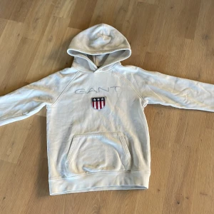 Beige Gant hoodie st 146/152 - En begagnad beige Gant hoodie i fint skick i st 146/152.  Frakt 50kr
