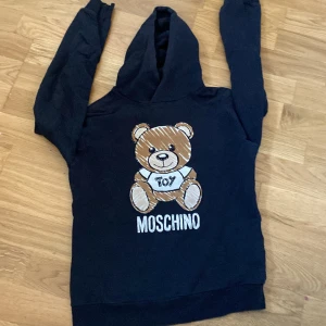 Moschino hoodie - 8/10 skick ett håll bak på tröjan som ni kanske ser på bilderna men annars e den jätte bra skick storlek 142