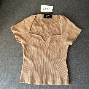 Stickad kortärmad tröja - En formgivande stickad tröja med strechig material. Frakt tillkommer efter!