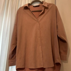  Skjorta  - Vid skjorta man kan ha under våren/ sommaren. Storken L men känns mer som M ocersize S. Pris kan diskuteras