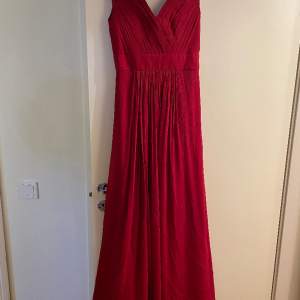 Vinröd klänning från Sofia Moore, ungefärlig storlek 36/38. Bara använd en gång så i mycket bra skick.  Går ned till golvet för mig som är 172 cm lång. Omfång över bröstkorgen: 74 cm runt Se bild för mått.