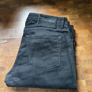 Jacob Cohen, svarta, 33 - Säljer svarta Jacob Cohen, size 33, modell Nick. Lite fade i färgen, men mycket liv kvar.