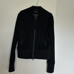Läderjacka Tiger of Sweden sz Medium - Svart läderjacka från stiger of Sweden.  Mycket fint skick, sparsamt använd.  Tvättas på kemtvätt inför försäljningen.   Material: 100% getskinn (insida polyester och nedre gräns av bomull men själva lädret är 100% getskinn)