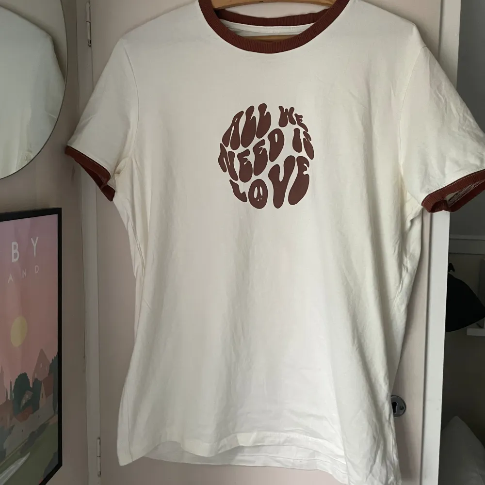 En brun och gräddvit 70-tals T-shirt med tryck från bershka  Storlek L . T-shirts.