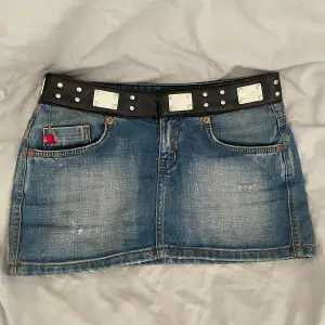 En unik lågmidjad minikjol i jeansmaterial, med svart skinn som ett ”bälte” längst upp. Strl 24, sitter som en XS/S. Köpt på humana för 300kr😊💗