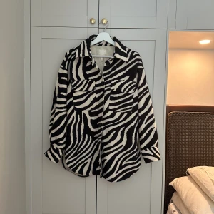 Zebrarandig overshirt - En zebrarandig overshirt/jacka i fleeceliknande material. Lappen är lite fläckig, men jackan är i använt men bra skick. Small men passar M och L i och med att den är oversize.