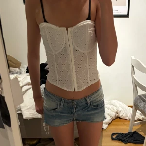 Korsett liknande topp - Fin topp. Går att bestämma själv hur man vill ha den eftersom det finns sonen längs med hela. Köpt på HM och aldrig använd
