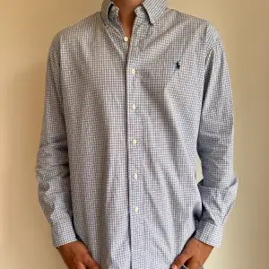 Blå rutig Ralph Lauren skjorta i storlek L. Skjortan är i fint skick utan några skavanker. Modellen är 186 cm lång. Orginalpris ca 1500 kr och nu endast 499. 