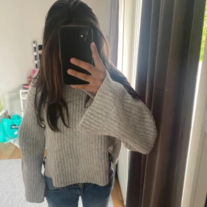Tröja ginatricot - Säljer denna gråa fina stickade tröjan ifrån gina tricot, den är använd få gånger så i fint skick! Den är vid i armarna med slit i armarna och i sidorna på tröjan.