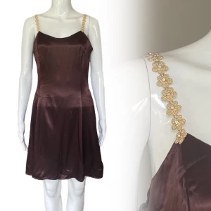 Klänning  - Från Jessica McClintock, Made in USA. 11/12 Brun/vinröd färg?  56% Acetate & 44% Rayon. Dockan använder storlek XS ⚠️ TITTA OM MÅTTEN PASSAR INNAN KÖP! Armhåla till armhåla 45cm Midjebredd cirka ~ 40cm  Längd 65cm 