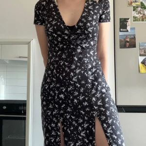 Klänning - Blommig klänning från Nelly. Två slitsar fram (syns på bild).  Köpt 2020. Endast använd 3 gånger. 